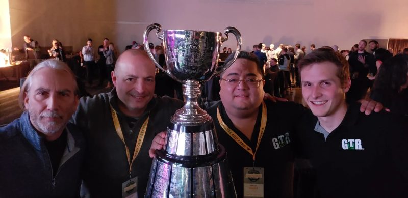 GTR Turf team members posing with a large trophy at an award ceremony or industry event celebration
